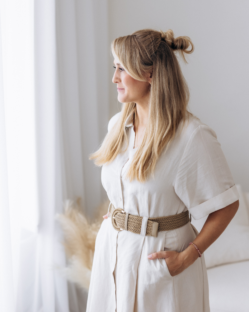 Kristy Stehnová z projektu RestartujSe s Kristy stojí u okna v světlém prostoru a dívá se do dálky, klidná a zamyšlená atmosféra.