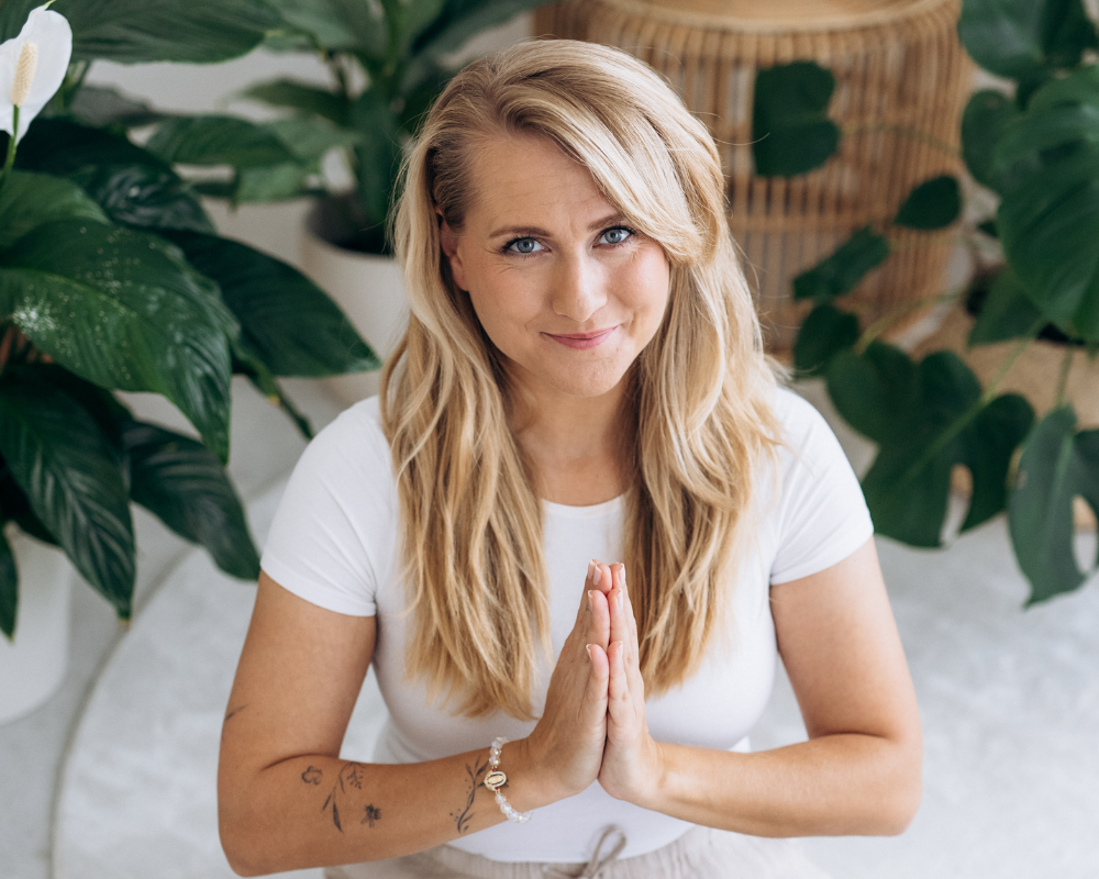 Kristy Stehnová z RestartujSe s Kristy v meditativní pozici s gestem namasté, klidný a podporující výraz.